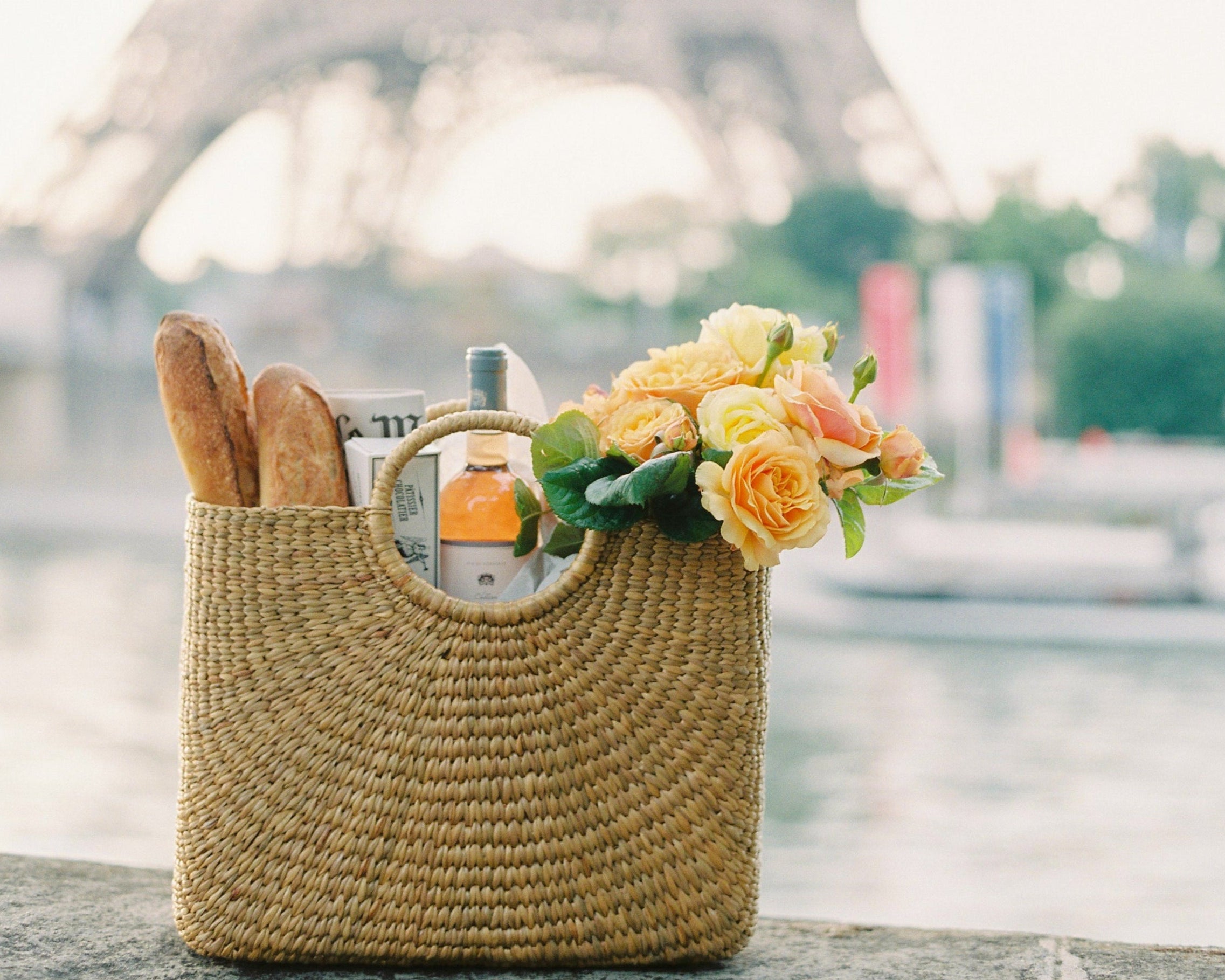 Woven bag with flowers and bread in front of the Eiffel Tower